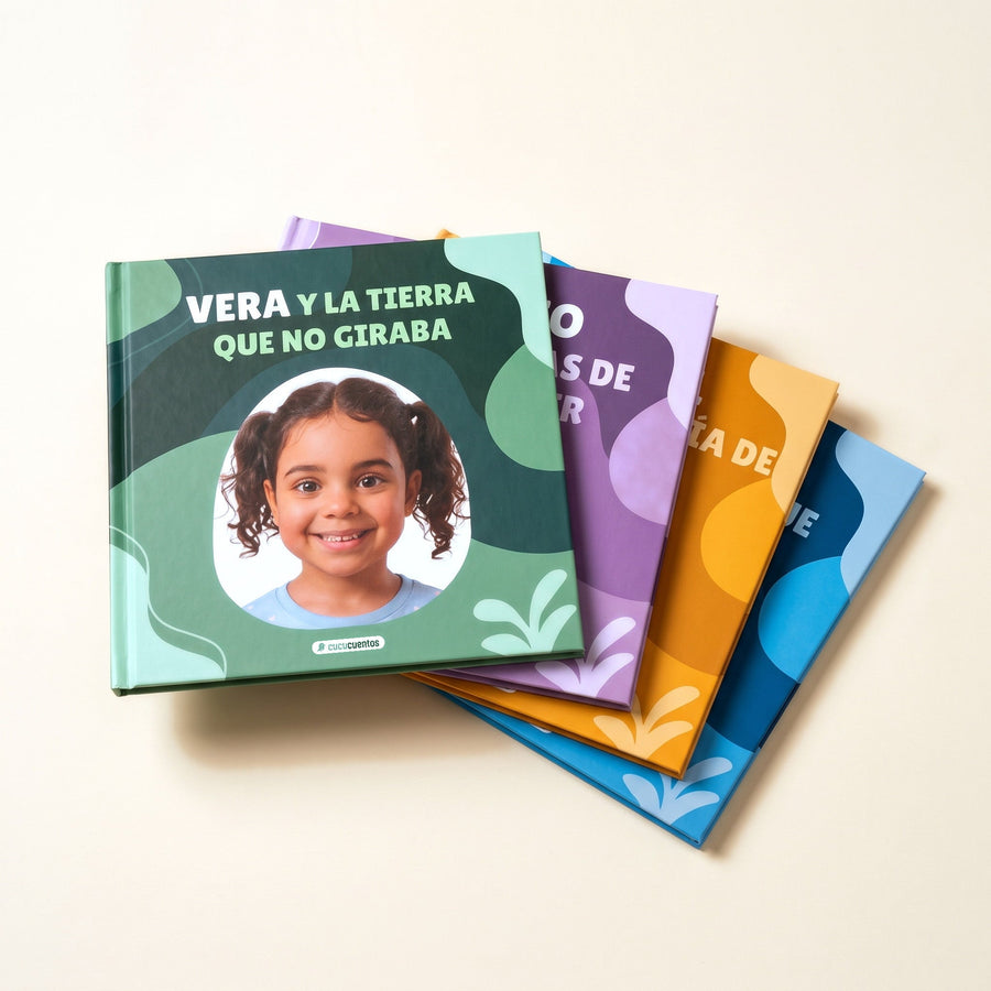 Cuentos personalizados en abanico sobre una mesa, cada uno con su color de cubierta y el verde encima
